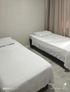 two beds sitting next to each other in a room at Apartamento no centro de Caxias com elevador e garagem in Caxias do Sul