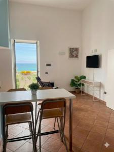 a living room with a table and chairs and a window at Casa Nina-Bacoli Elegant & View in Bacoli