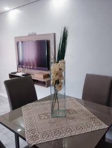 a table with a vase with flowers on it at Apartamento no centro de Caxias com elevador e garagem in Caxias do Sul