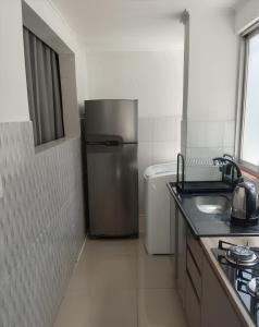 a kitchen with a stainless steel refrigerator and a sink at Apartamento no centro de Caxias com elevador e garagem in Caxias do Sul