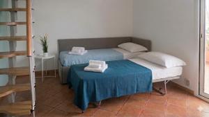 a room with two beds and a table with towels at Casa Nina-Bacoli Elegant & View in Bacoli