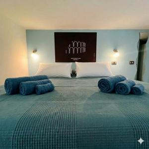 a large bed with blue pillows on top of it at Casa Nina-Bacoli Elegant & View in Bacoli +3 photos