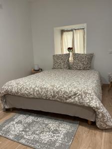 a bedroom with a large bed with a vase on it at Au numéro 10 in Jonzac