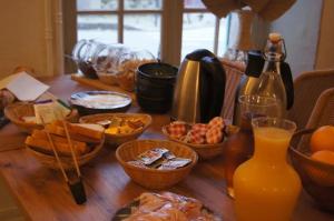 a wooden table topped with bowls of food and orange juice at L'Harmony in Saint-Arnoult-en-Yvelines