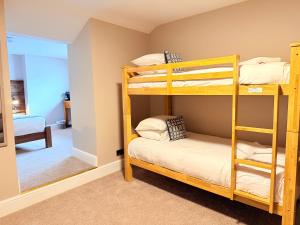 a bedroom with two bunk beds and a mirror at Tanronnen Inn in Beddgelert