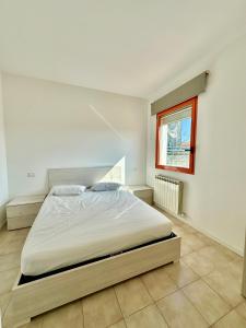 a bedroom with a large bed in a white room at Solleone 18 - Sea, Sun e Pool in Cavallino-Treporti