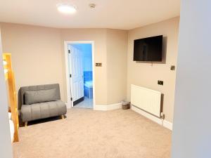 a living room with a chair and a television at Tanronnen Inn in Beddgelert