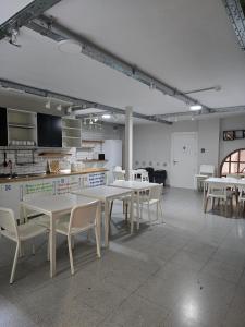 a room with tables and chairs and a kitchen at Hostel Catedral Burgos in Burgos