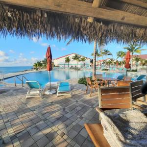 a resort patio with a pool and chairs and umbrellas at Bimini Paradies South Bimini North Bimini Bahamas Bimini 10B Alice Town in South Bimini