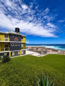 a yellow building with a view of the ocean at Casa BB&Djassi - SUITES in Ponta do Sol