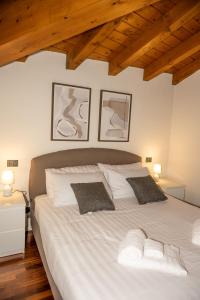 a bedroom with a large white bed with two pillows at Liberty Apartment in Lovere