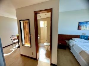 a hotel room with a bed and a mirror at Sumatra Hotel e Centro de Convenções in Londrina