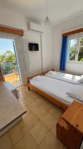a bedroom with a large bed and a balcony at Faros Rooms Armenistis in Armenistis