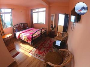 a bedroom with a bed and a table and chairs at Laskus Homestay in Darjeeling