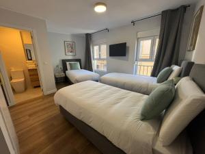 a hotel room with two beds and a television at Hostal Guzman El Bueno by gaiarooms in León
