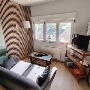 a living room with a couch and a table at Studio Augustine, studio pour une pause en Baie du Mont Saint Michel in Roz-sur-Couesnon