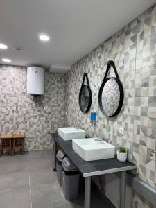 a bathroom with two sinks and mirrors on the wall at Albergue el cristo in Porriño