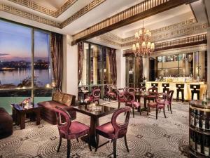 a living room with tables and chairs and a bar at Fairmont Nile City in Cairo