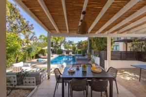a patio with a table and chairs and a pool at Villa Mylos 7 in Protaras