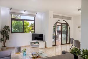 a living room with a flat screen tv and a couch at Villa Mylos 7 in Protaras