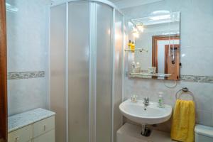 a bathroom with a shower and a sink at Brisa de Sesimbra - Spacious Family Apartment, 5min Walk to the Beach with Private Parking in Sesimbra +23 photos