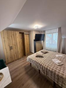 a bedroom with a large bed and wooden floors at Eclipse grill and pizza in Corunca +21 photos
