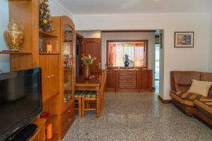 a living room with a couch and a television at Brisa de Sesimbra - Spacious Family Apartment, 5min Walk to the Beach with Private Parking in Sesimbra