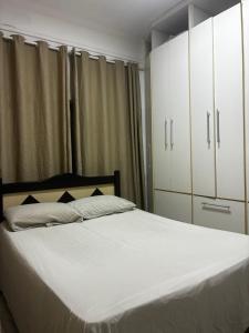 a bedroom with a large bed with white cabinets at Casa 100mtrs do mar com piscina aquecida in Solemar +21 photos