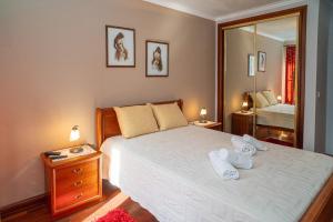 a bedroom with a large bed with towels on it at Brisa de Sesimbra - Spacious Family Apartment, 5min Walk to the Beach with Private Parking in Sesimbra
