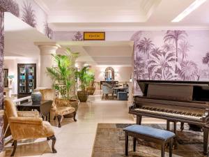 a living room with a piano and a table at Fairmont The Norfolk in Nairobi