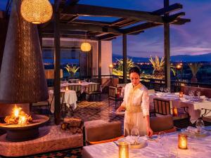 a woman standing at a table in a restaurant at Fairmont Royal Palm Marrakech in Marrakesh +245 photos