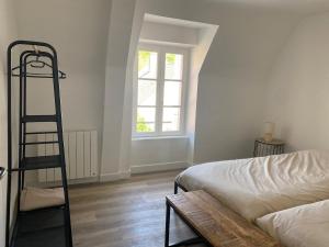 a bedroom with a ladder next to a bed and a window at La Factory Saint Aignan in Saint-Aignan