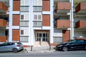 two cars parked in front of a building at Brisa de Sesimbra - Spacious Family Apartment, 5min Walk to the Beach with Private Parking in Sesimbra
