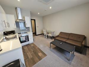 a living room with a couch and a kitchen at The Westbourne Residences in London +39 photos