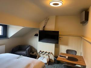 ein Schlafzimmer mit Bett und Flachbildfernseher in der Unterkunft Cozy Boutique hotel-Guesthouse Leuven -self check in in Löwen