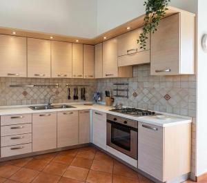 a kitchen with white cabinets and a stove top oven at Casa Nina-Bacoli Elegant & View in Bacoli
