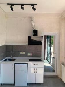 a kitchen with white cabinets and a counter top at Kobuleti hotel 656 in Kobuleti