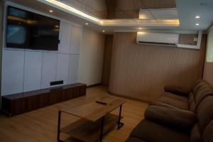 a living room with a couch and a table and a tv at Blue Sea Explorer in Male City