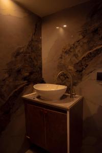 a bathroom with a sink and a stone wall at Blue Sea Explorer in Male City +30 photos