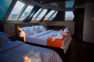 two beds in a room with windows on a boat at Blue Sea Explorer in Male City