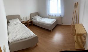 a room with two beds and a table and a window at Gästeapartment in ruhiger Lage in Rainau