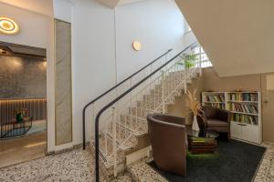 a spiral staircase in a living room with a chair at Hotel Schöne Altmark in Kalbe
