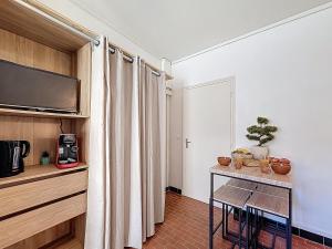 a room with a table with chairs and a television at Le Nid d'andéol in Bourg-Saint-Andéol