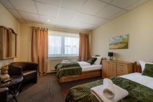 a hotel room with two beds and a chair at Hotel Schöne Altmark in Kalbe +37 photos
