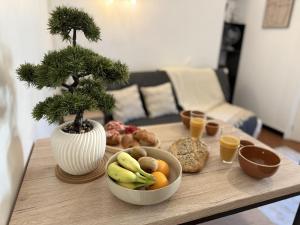 a table topped with bowls of fruit and a bonsai tree at Le Nid d'andéol in Bourg-Saint-Andéol +2 photos