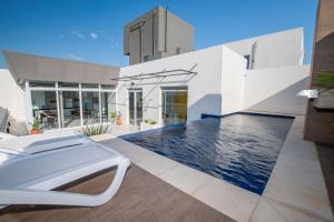 a swimming pool in the backyard of a house at Cityscape Views - New 2BR Retreat in Asunción