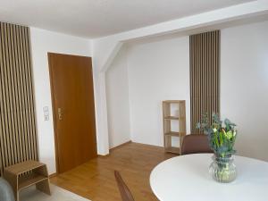 a room with a table with a vase of flowers on it at Gästeapartment in ruhiger Lage in Rainau +1 photo