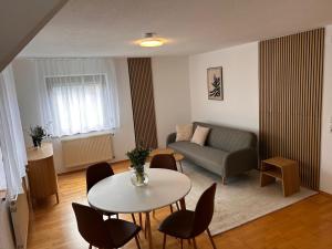 a living room with a couch and a table and chairs at Gästeapartment in ruhiger Lage in Rainau