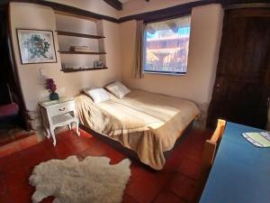 a small bedroom with a bed and a window at The Witch's Cottage in Urubamba