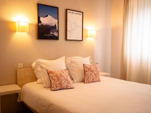 a hotel room with a bed with two pillows at Fuzei Hôtel Lorient-Lanester in Lanester